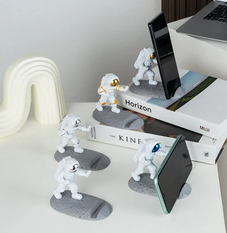 Astronaut decoration spaceman plastic mobile phone holder in blue, gold, and silver colours for lazy binge-watching