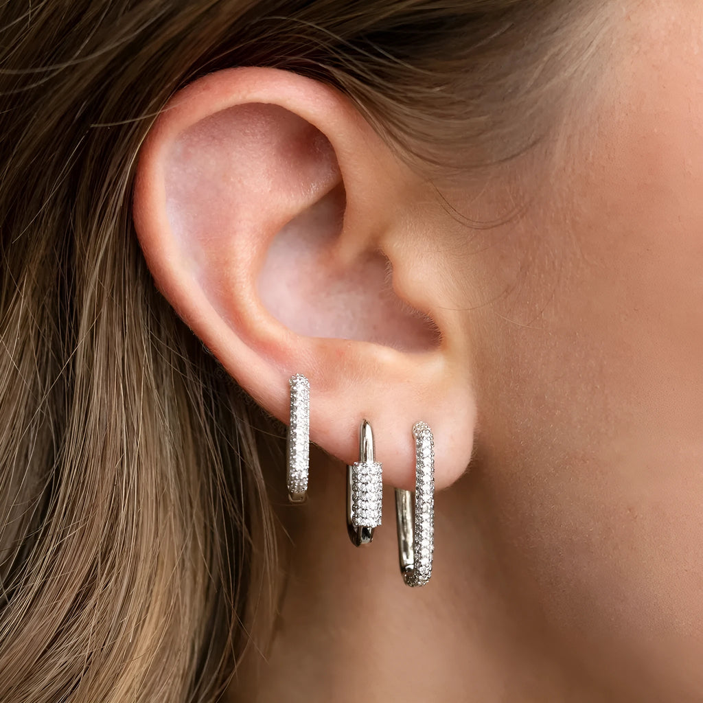 Three geometric copper earrings with inlaid zircon on a square clip, in gold and white finishes.
