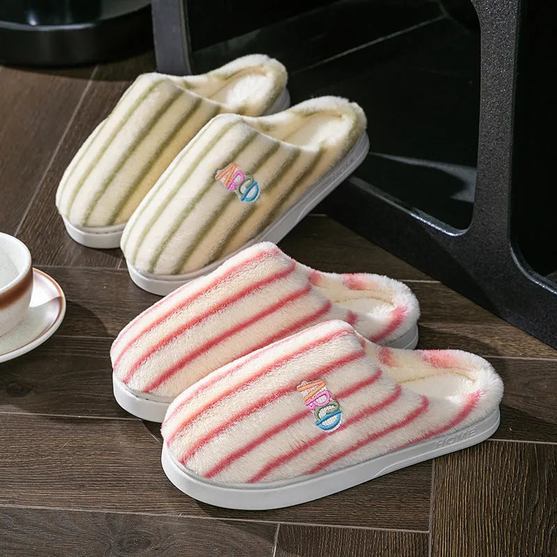 A pair of colourful vertically striped cotton flip flop slippers for adults on a plain background.