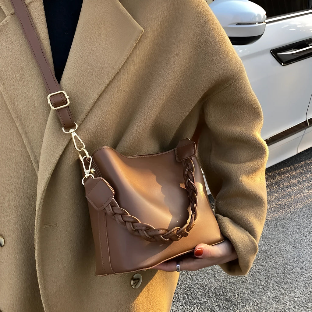 Retro khaki woven crossbody bucket bag with adjustable strap shown worn on shoulder