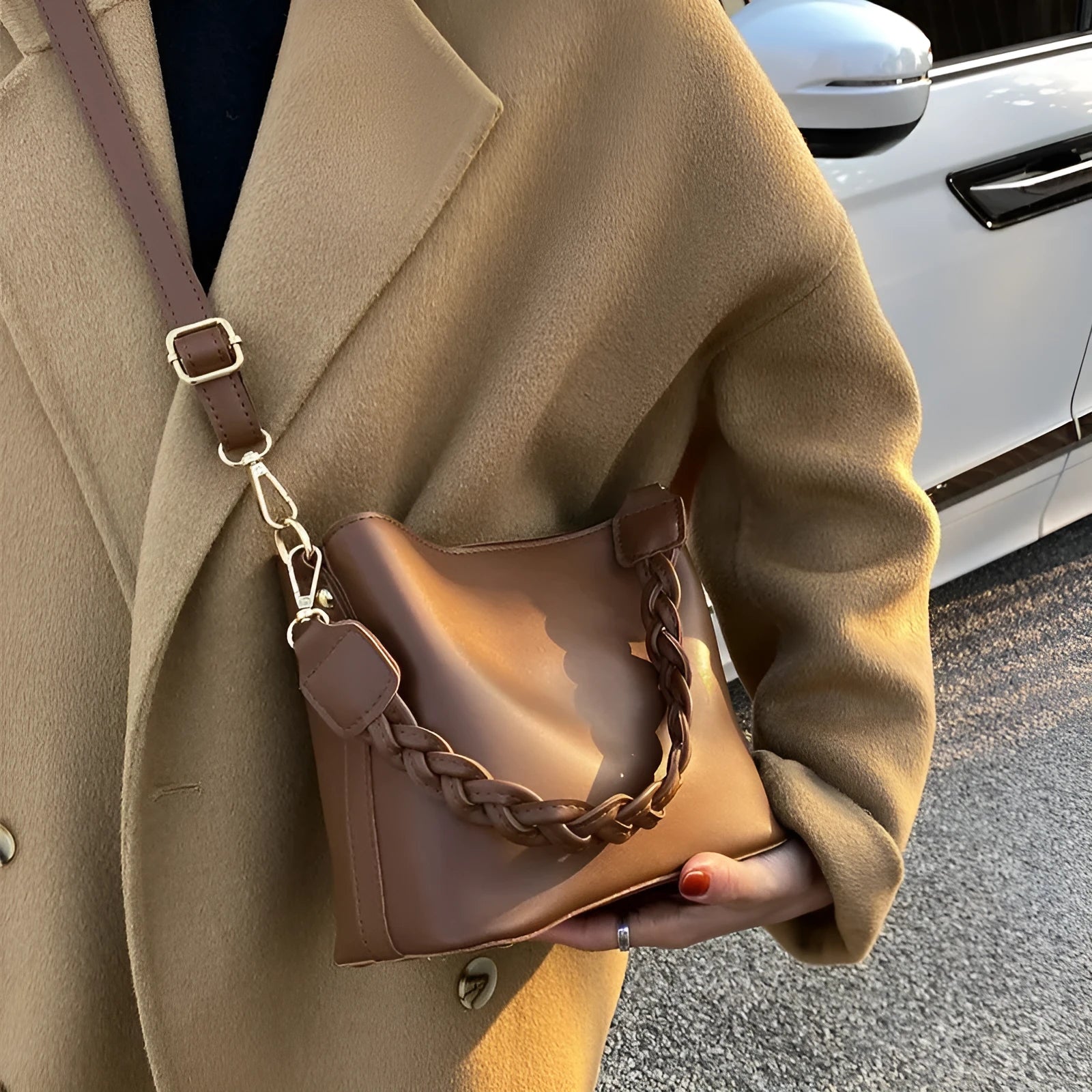 Retro khaki woven crossbody bucket bag with adjustable strap shown worn on shoulder