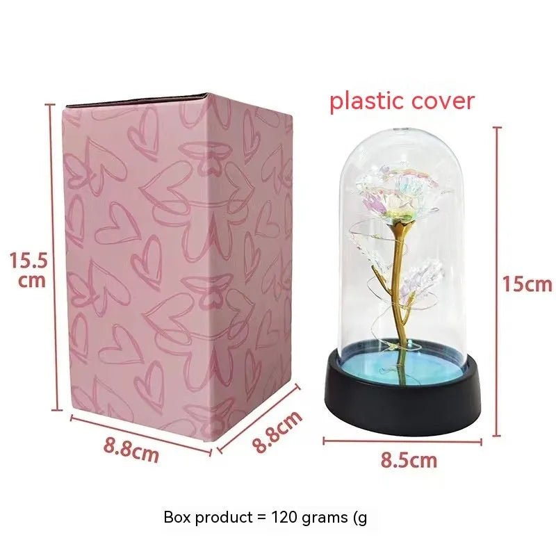Small plastic decorative night lamp with coloured glass cover and black base on a table.