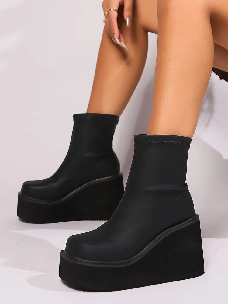 Plus size black women's wedge heel boots with a waterproof platform sole and round toe.