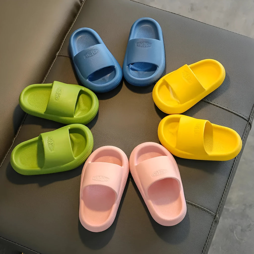 Colourful children's EVA slippers with textured non-slip sole, shown in blue, green, orange, pink, and yellow.