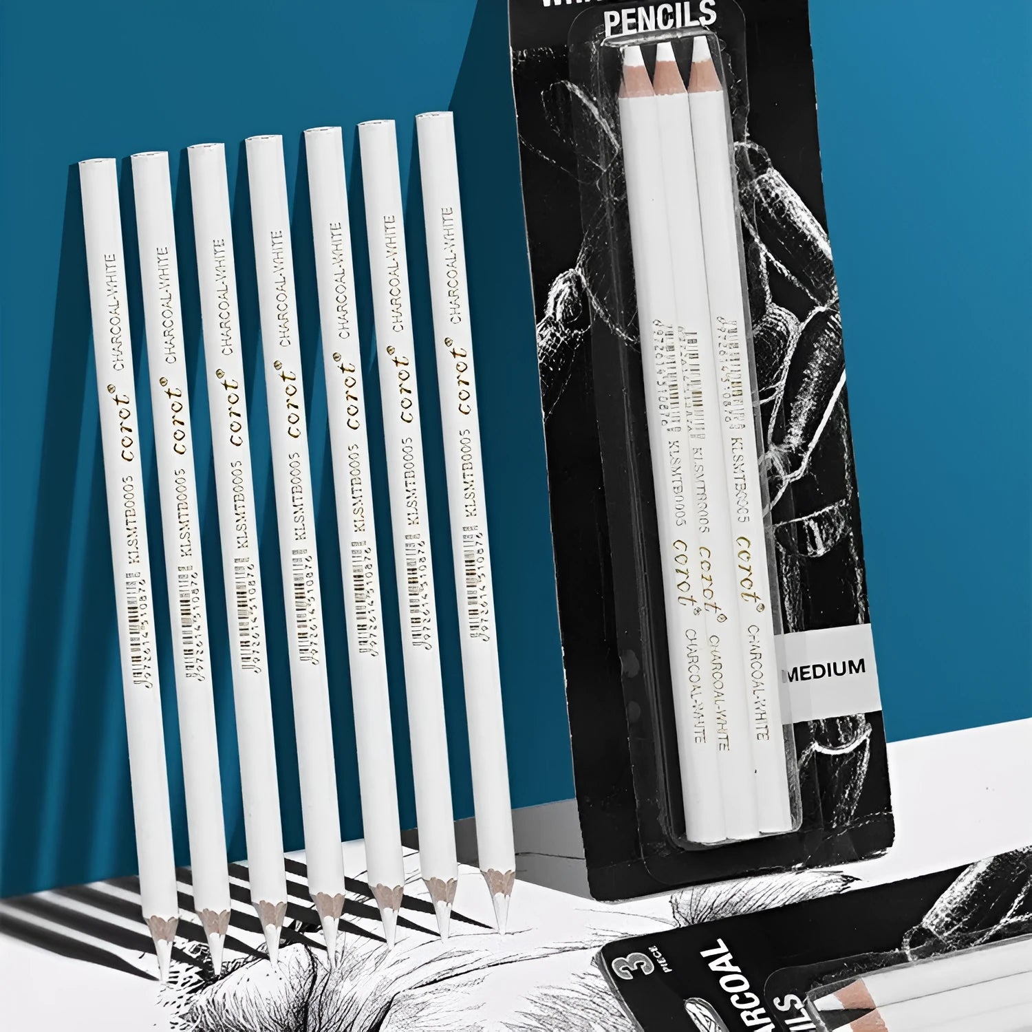 Set of three white charcoal sketching pencils in wooden casings.