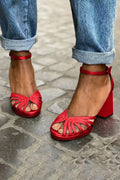 Women's red peep toe sandals with buckle strap and herringbone toe detail on a high heel.