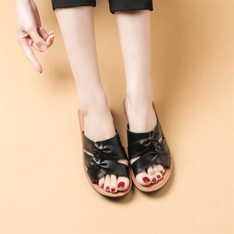 Beige women's cowhide mom sandal slippers with straps and a soft sole on a white background.