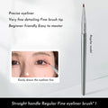 Close-up of a black angled eyeliner brush with a fine point, bent at 45 degrees for precise makeup application.