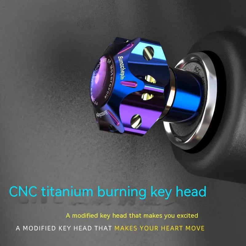 Close-up of a T6 aluminium alloy motorcycle key head cover in a hexagonal design with a blue and white keychain.
