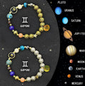 Two natural stone beaded bracelets with metal zodiac sign charms laid flat.