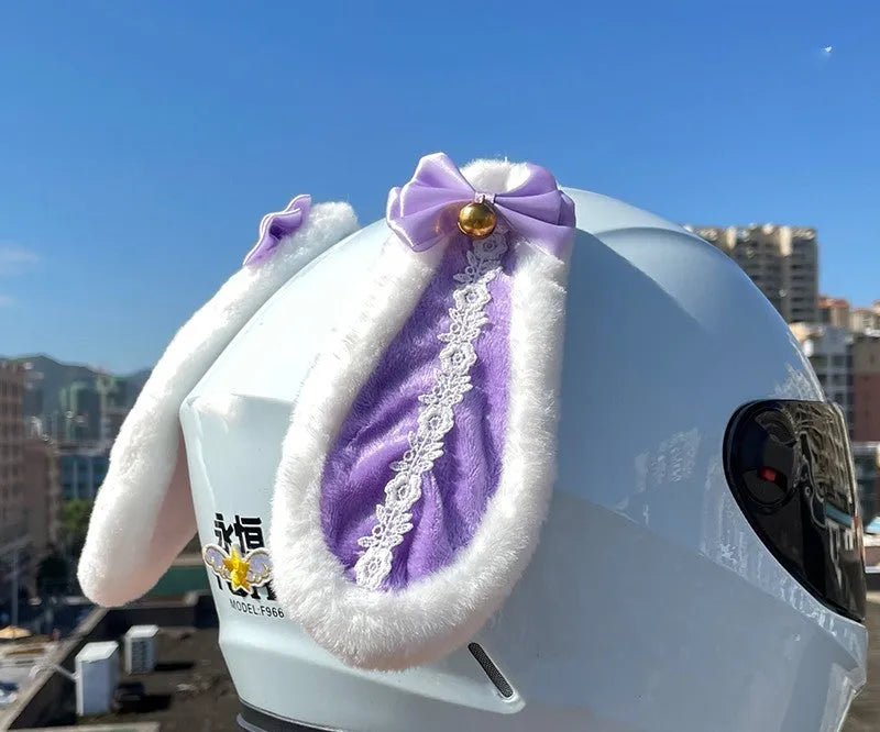 Carbon fibre rabbit ear decoration attached to a black motorcycle helmet, showing clip-on mechanism.