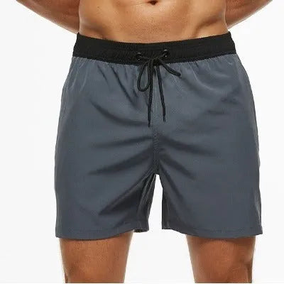 Men's blue drawstring athletic shorts with a zip pocket and stitching detail on the waistband.