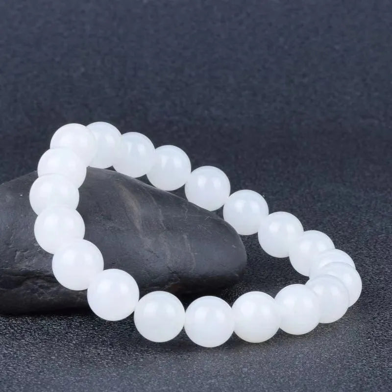 Hotan white jade goat fat round bead bracelet with 10mm Hetian jade beads on a neutral background