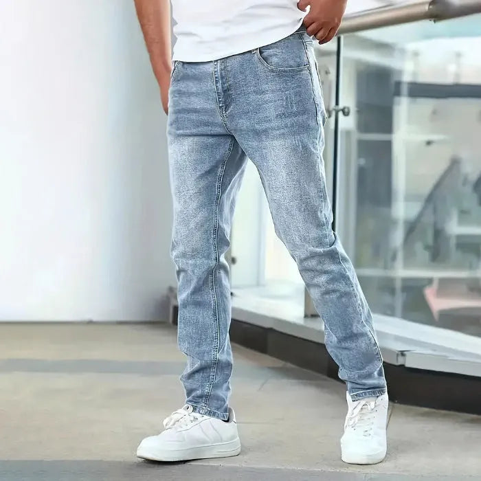 A pair of men's solid colour stretch jeans in a straight leg skinny fit, shown in dark blue.