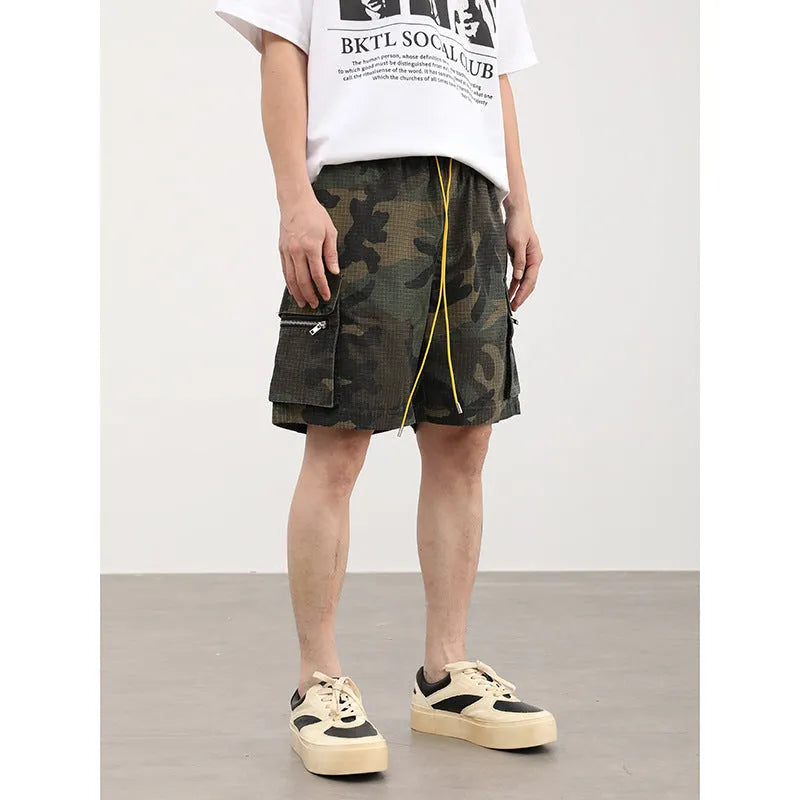Men's camouflage work shorts with multiple pockets showing cropped length and mid-waist design