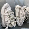 Women's grey clunky platform sneakers with a thick rubber sole and lace-up front, shown on a white background.