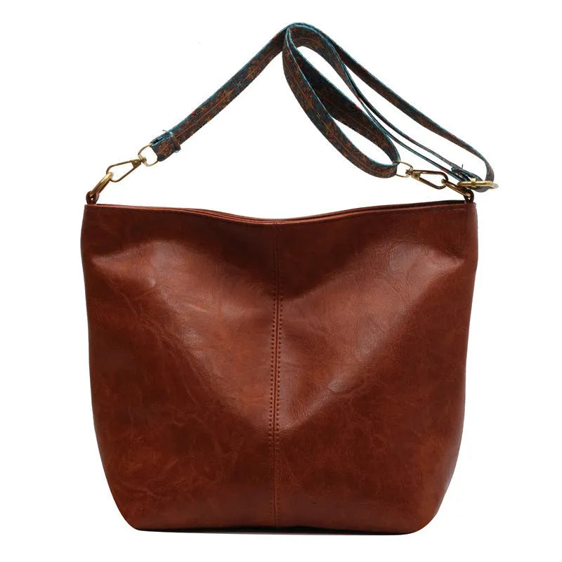Retro bucket bag with wide shoulder strap, solid colour in beige, shown from front angle