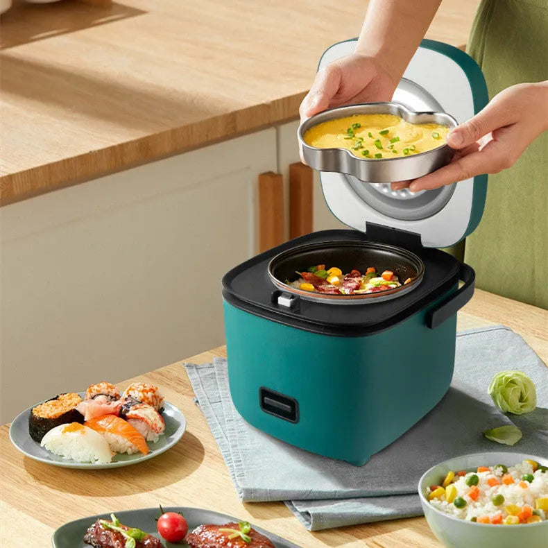 Green mini rice cooker 1.2L with steaming plate, rice spoon and measuring cup on countertop
