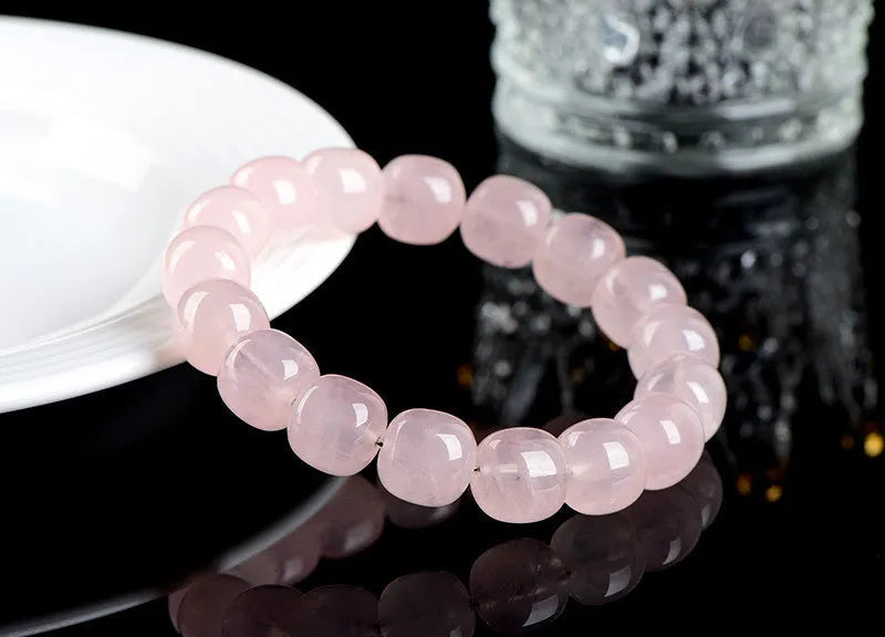 Pink crystal barrel bead bracelet with geometric beads on an elastic cord