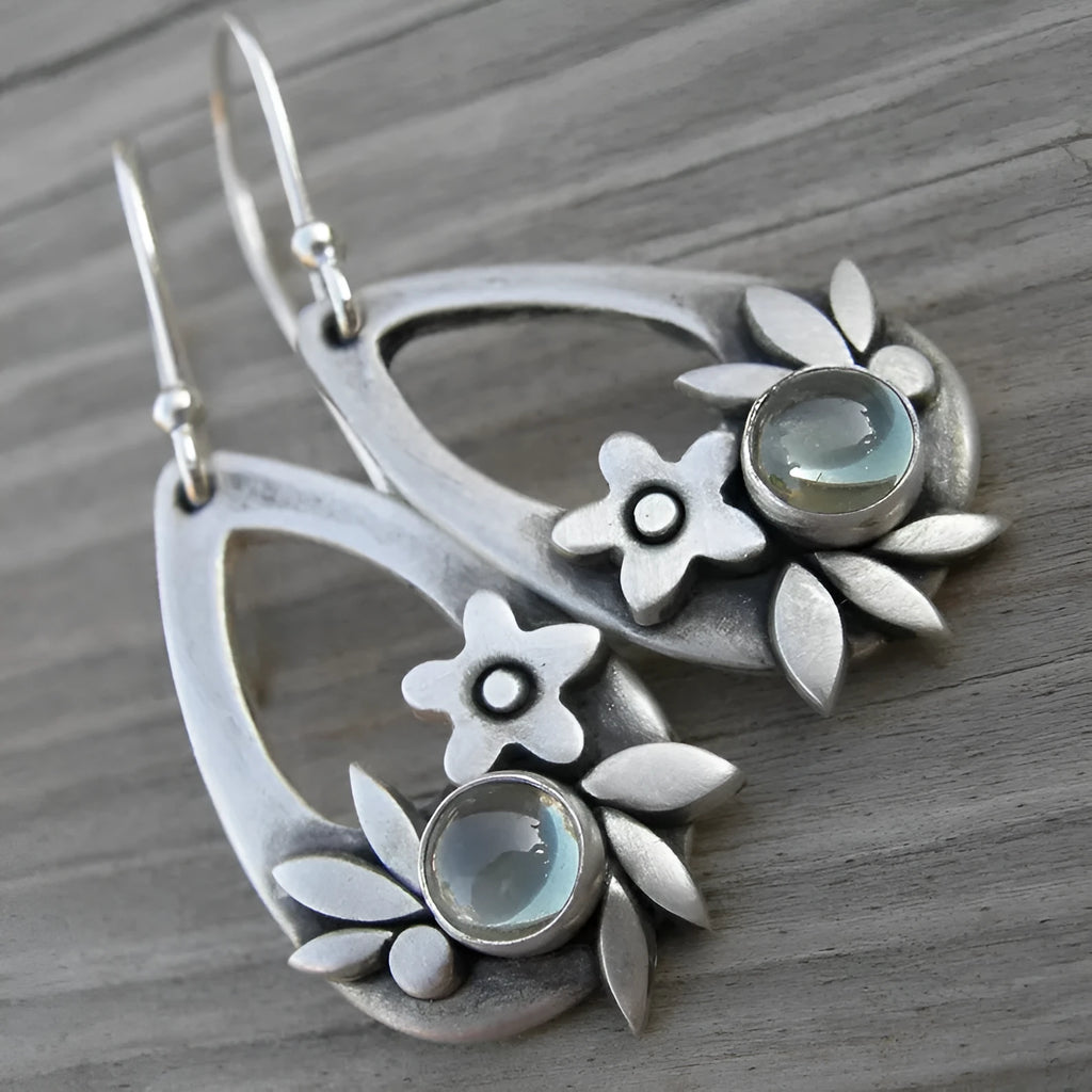 Silver ethnic style minimalist drop flower leaf alloy earrings with teardrop shape on neutral background