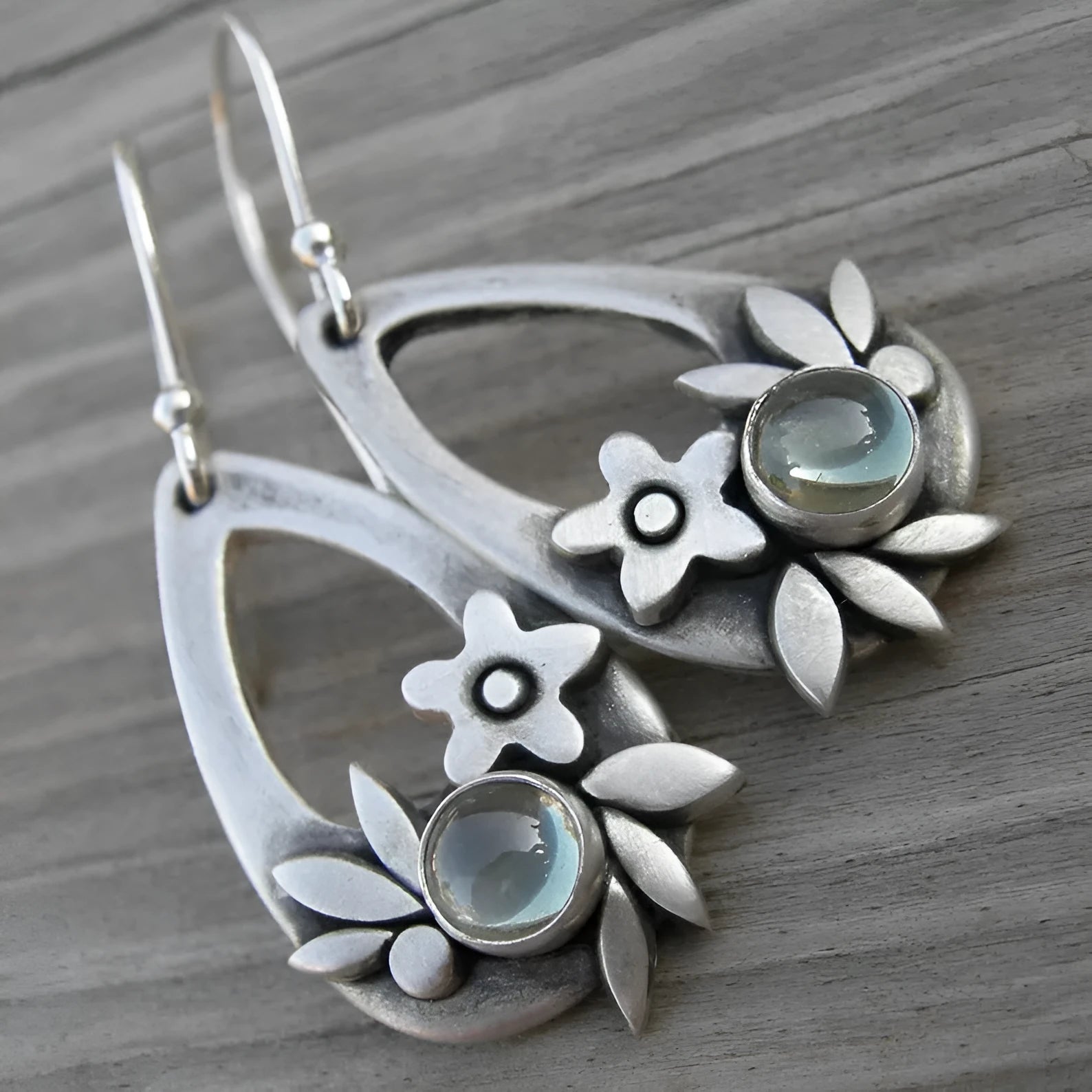 Silver ethnic style minimalist drop flower leaf alloy earrings with teardrop shape on neutral background