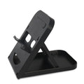Black adjustable ABS game console stand for Switch on a desktop surface