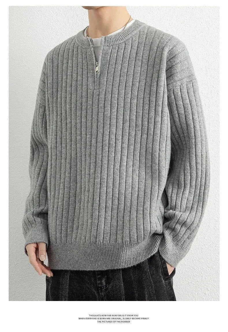 Man wearing a grey half-zip loose fit knitted sweater pullover.