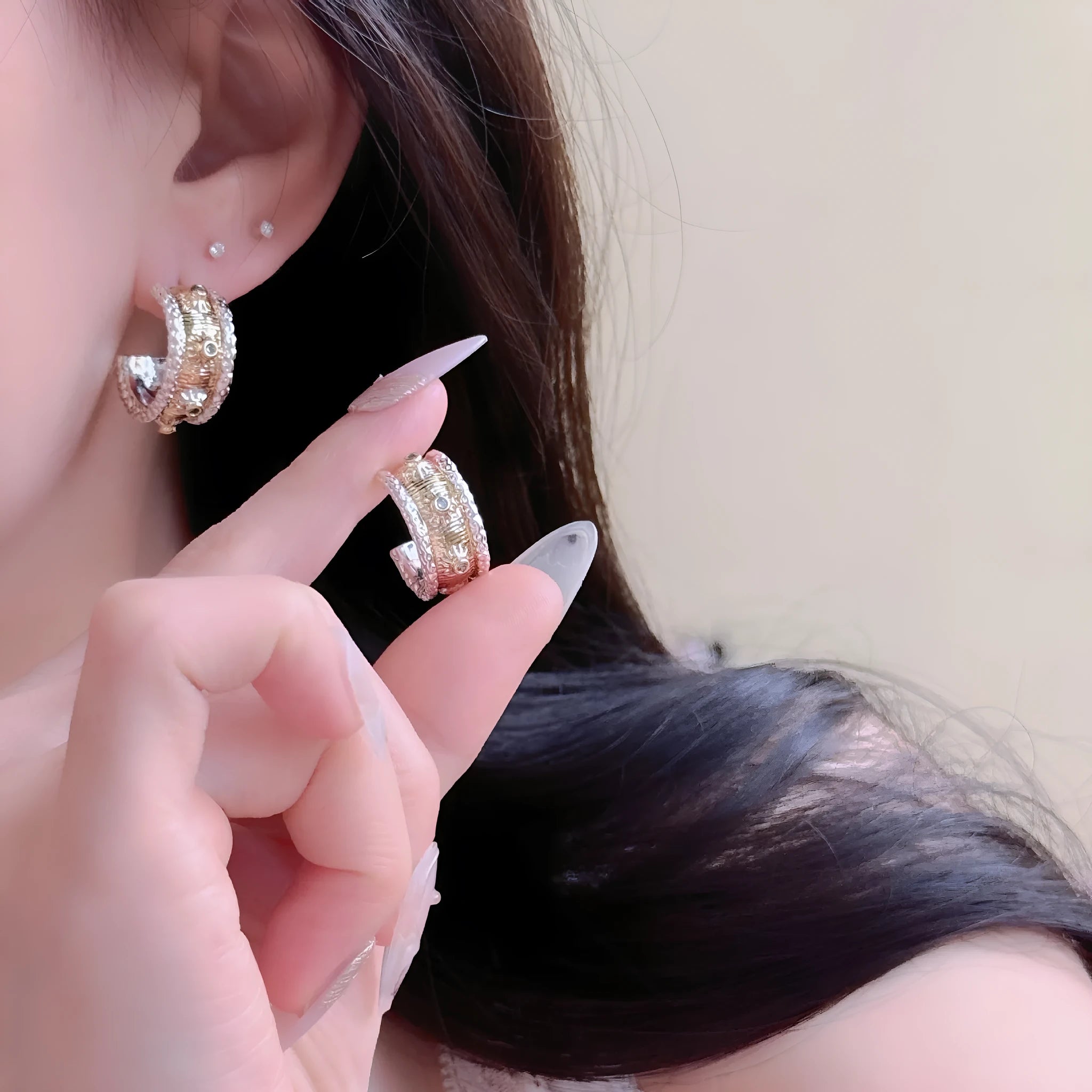Gold and silver C-shaped brushed ring earrings on display, copper with 925 silver needles