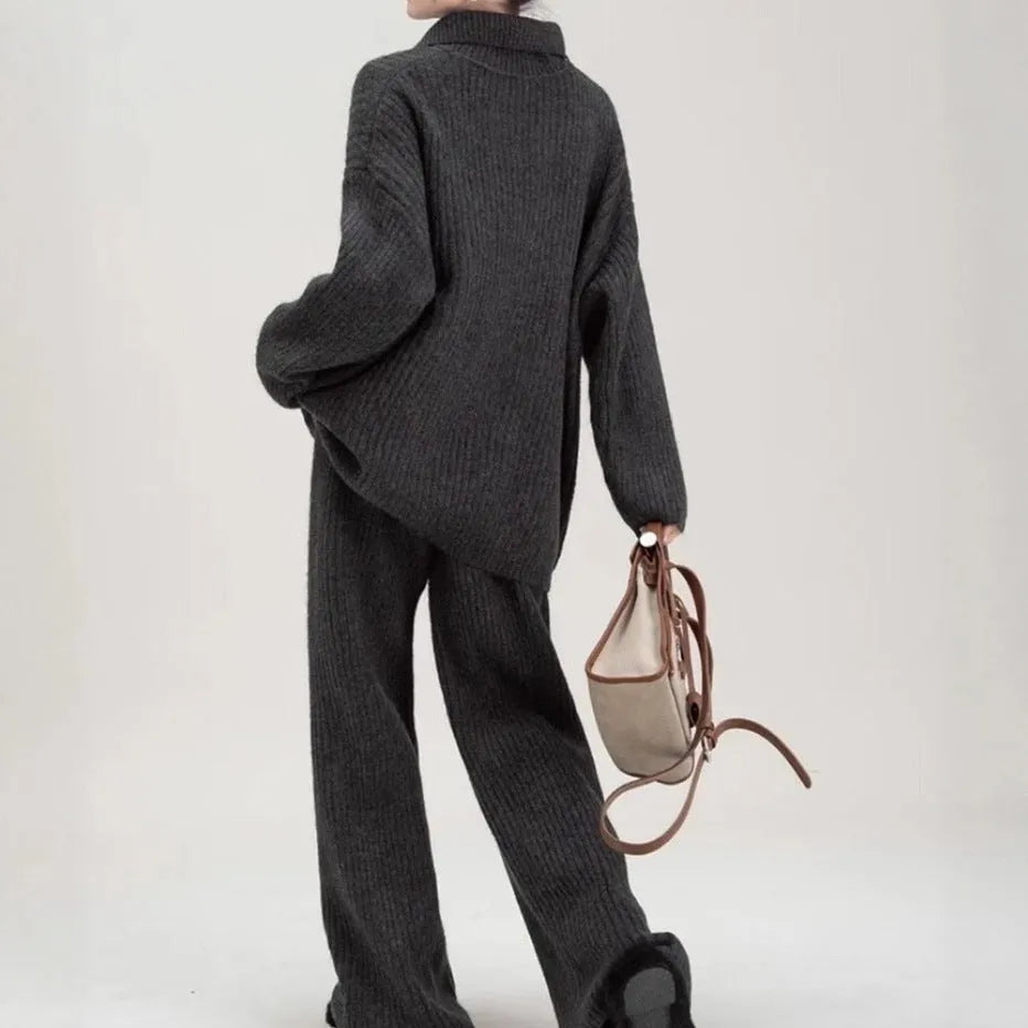 Beige women's knitted acrylic sweater and trouser two-piece set laid flat.