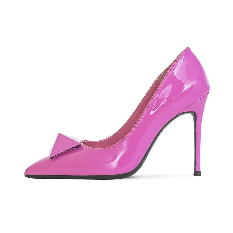 Women's pink patent leather pointed toe stiletto heels with an ankle buckle strap on a white background.