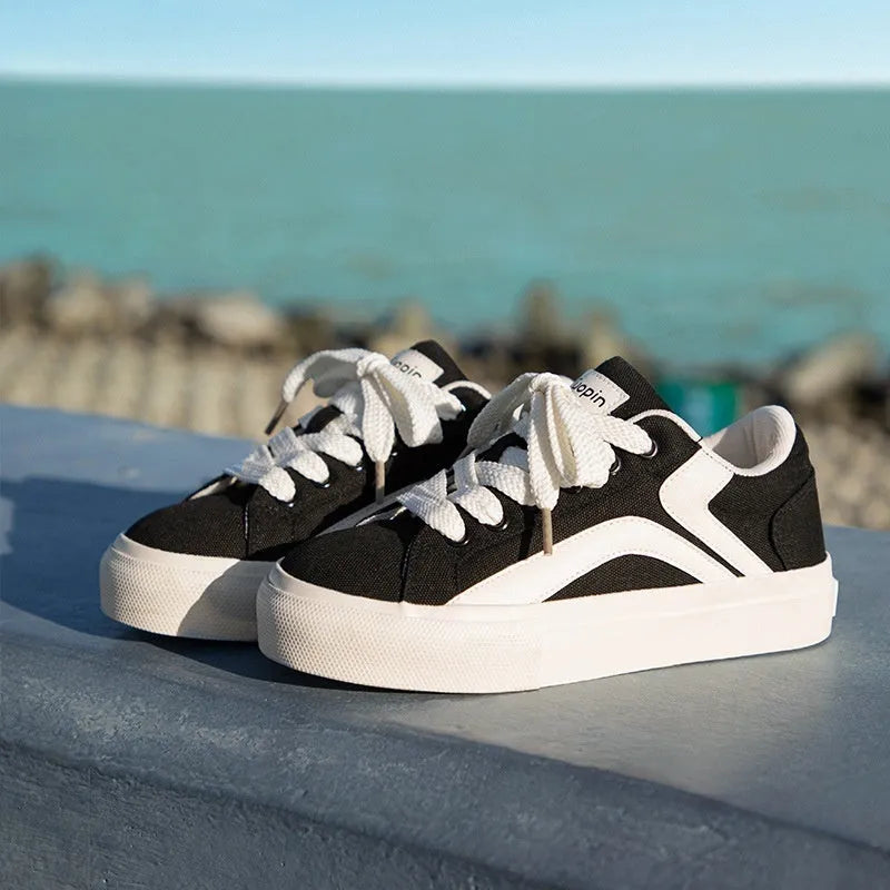 Women's low-top lace-up board shoes in synthetic leather with a vulcanised rubber sole, shown in a two-tone colour option.