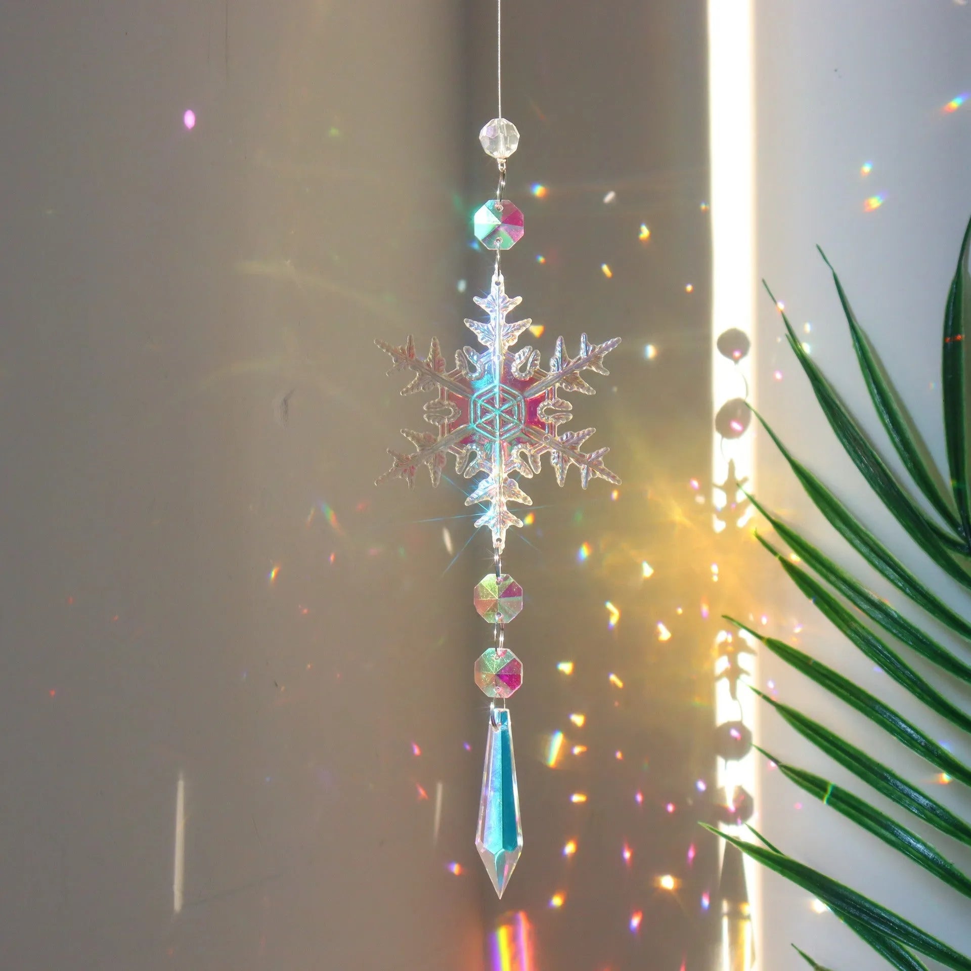 Colourful K9 crystal snowflake sun catcher with AB finish hanging as a window Christmas decoration.