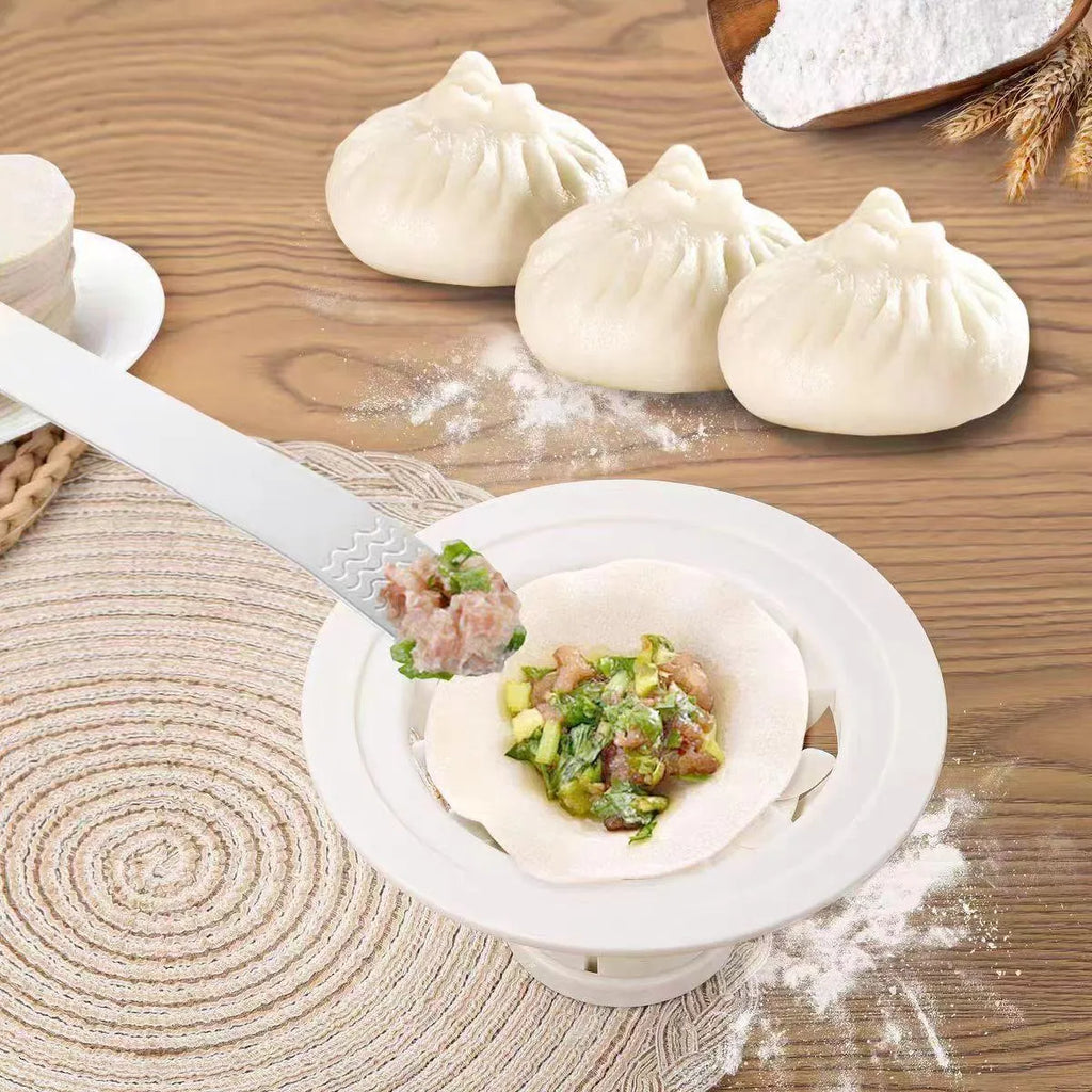 Set of four black plastic steamed bun and dumpling shaping moulds on a kitchen surface.