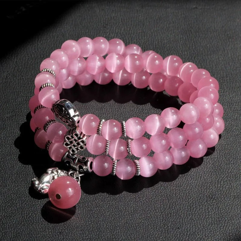 Women's opal bracelet with lucky cat charm, shown in a triple-wrap style with colourful geometric beads.