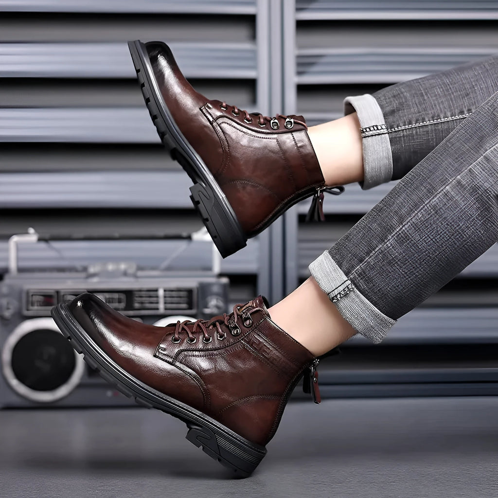 Black and brown leather Martin ankle boots with a rubber sole and visible stitching.