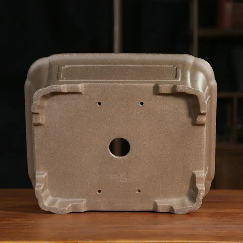 Rectangular antique purple sand bonsai pot with cut corners on a floor.