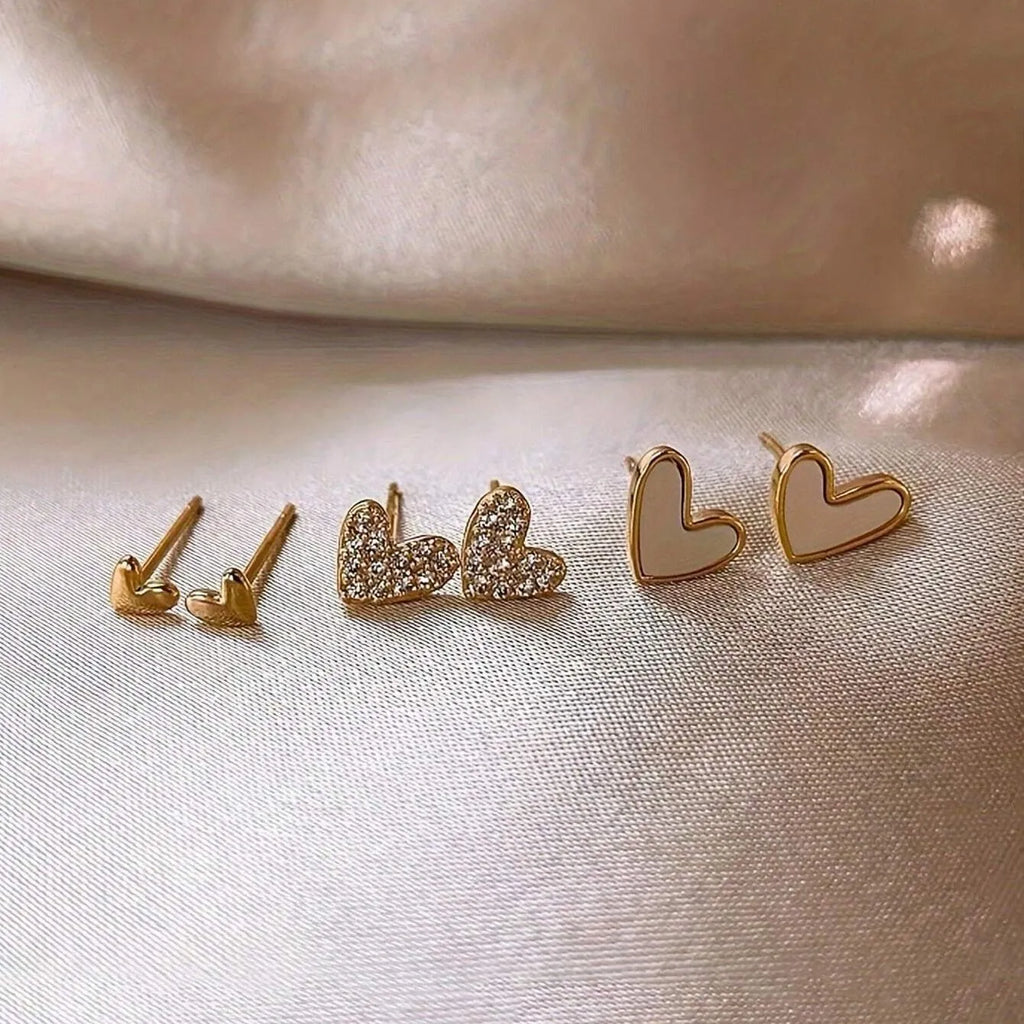 Set of three pairs of heart-shaped alloy earrings in gold, black, black and white, or pink colours