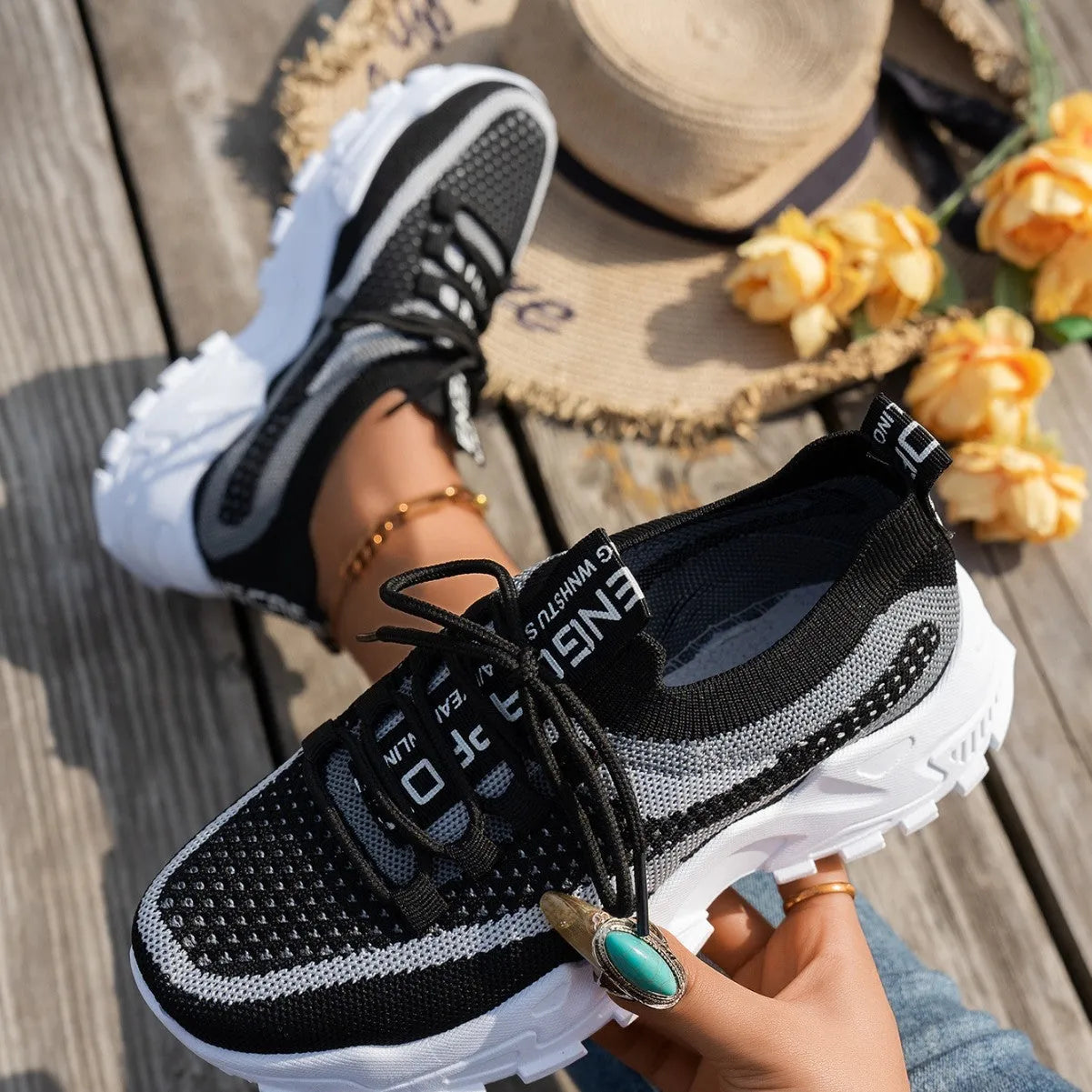 Women's Flyknit mesh lace-up sneakers in a grey colourway with a round toe and flat rubber sole.
