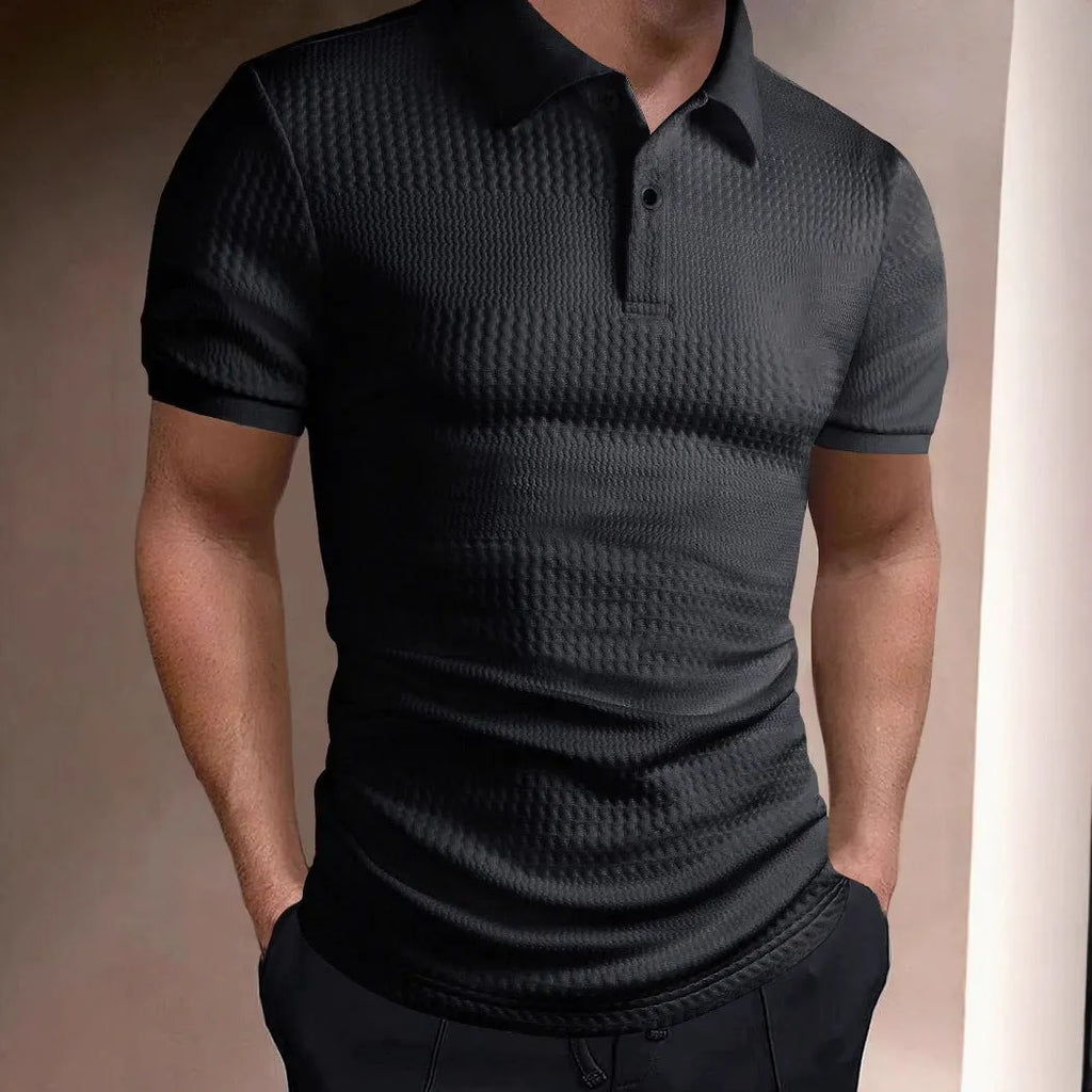 Man wearing a loose-fit striped polo shirt in a light blue colour, showing asymmetric detail and short sleeves.