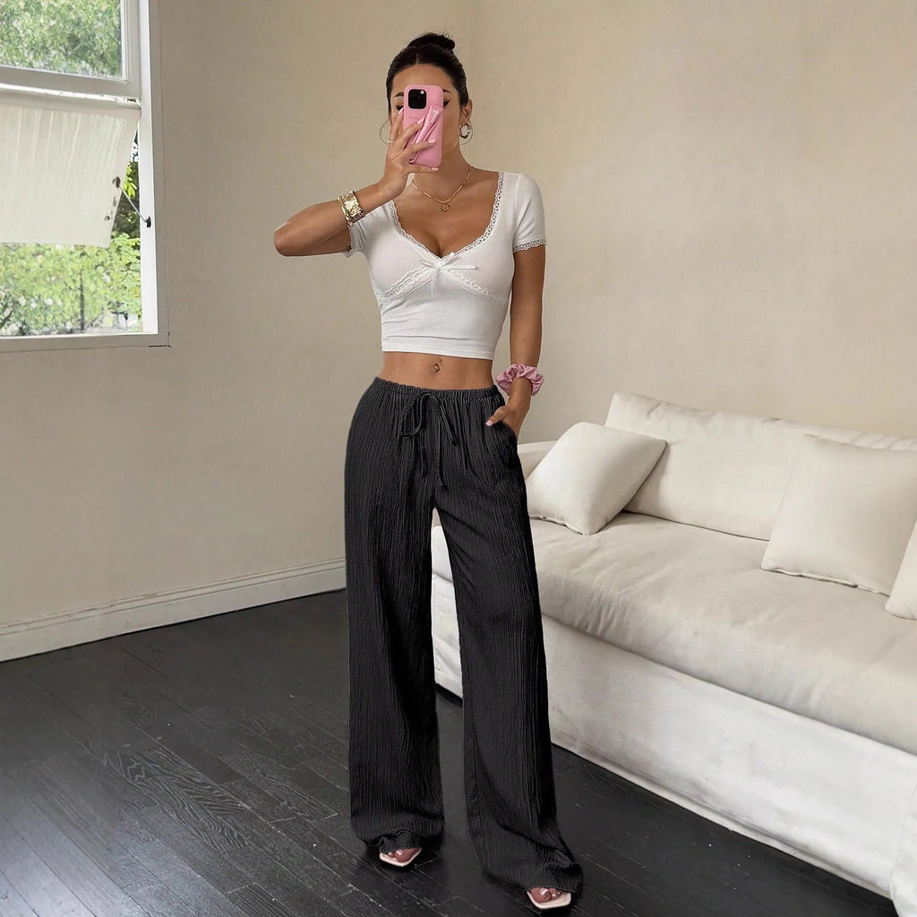 Women's black wide-leg trousers with a front lace-up waist detail on a mid-rise waistband.
