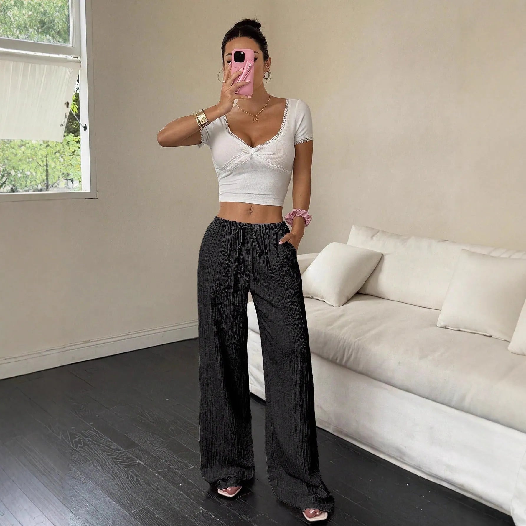 Women's black wide-leg trousers with a front lace-up waist detail on a mid-rise waistband.