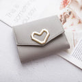 Women's PU leather tri-fold wallet with magnetic buckle, card slots, and coin pocket in black