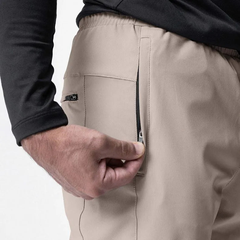 Men's grey loose-fit fitness trousers with ankle ties, made from quick-drying polyester fabric.
