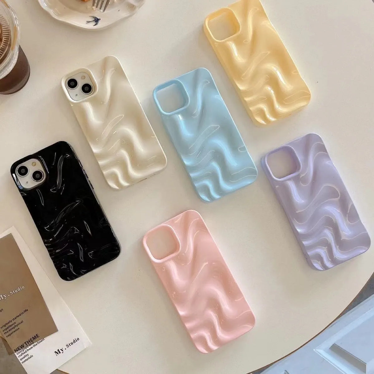 Three-dimensional pleated water ripple TPU phone case for iPhone 14 in glossy silver, showing textured back and edge coverage