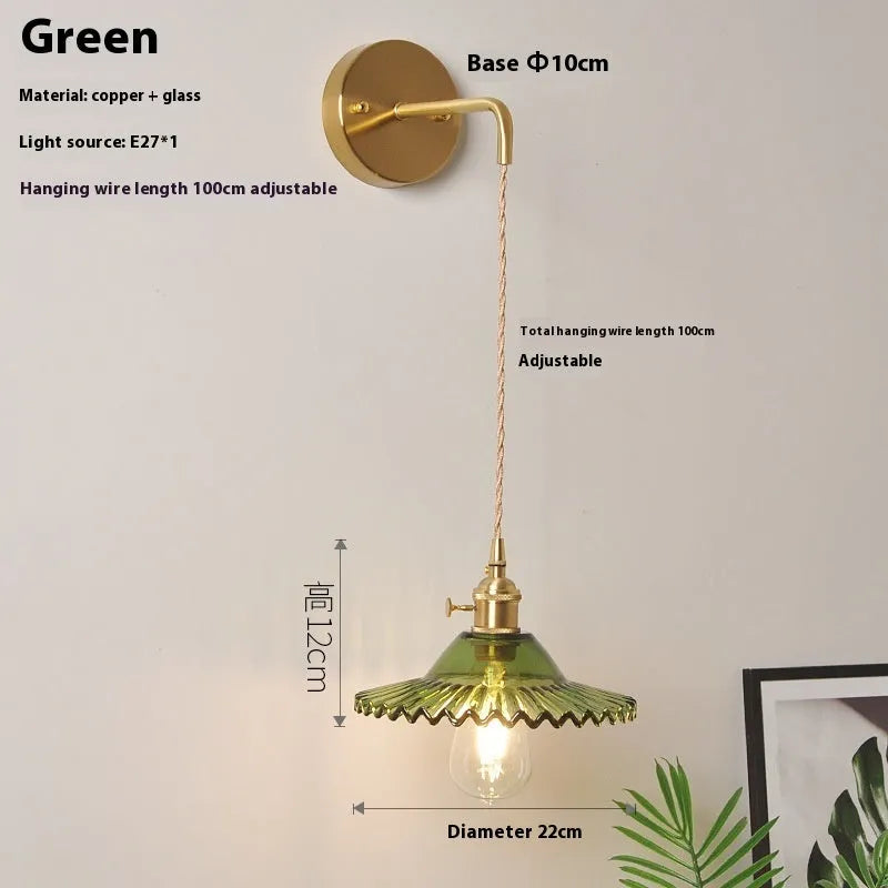 Retro brass-toned copper wall lamp with a white glass lotus shade mounted beside a bed.