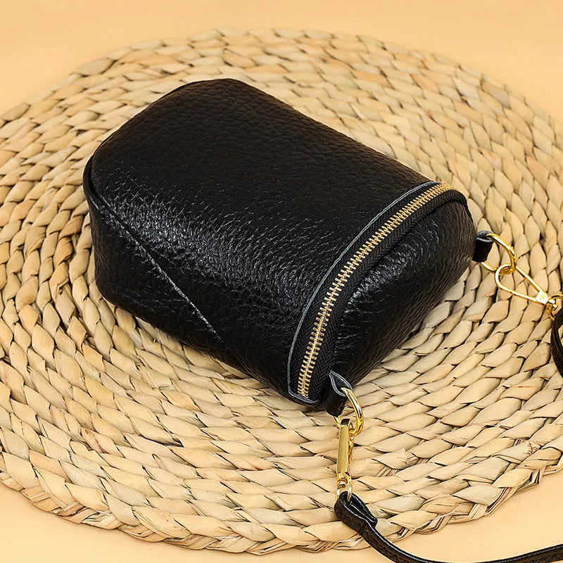 Genuine leather small crossbody bag in black with adjustable strap and shell shape design