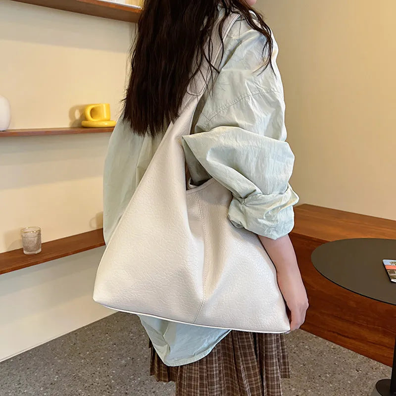 Women's large capacity soft PU shoulder bucket bag with contrast stitching in silver, front view