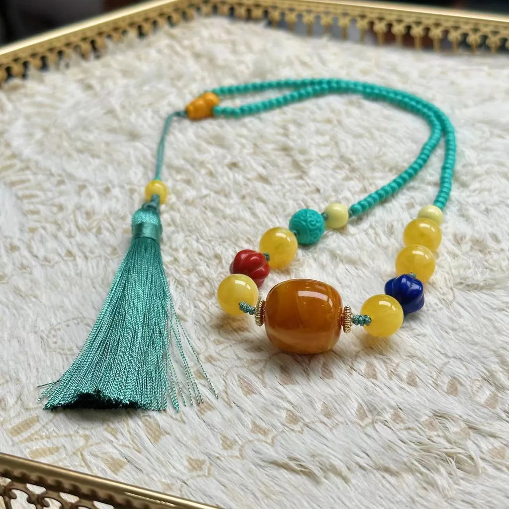Close-up of a hand-woven mesh flower turquoise pendant on an adjustable ball bead necklace.