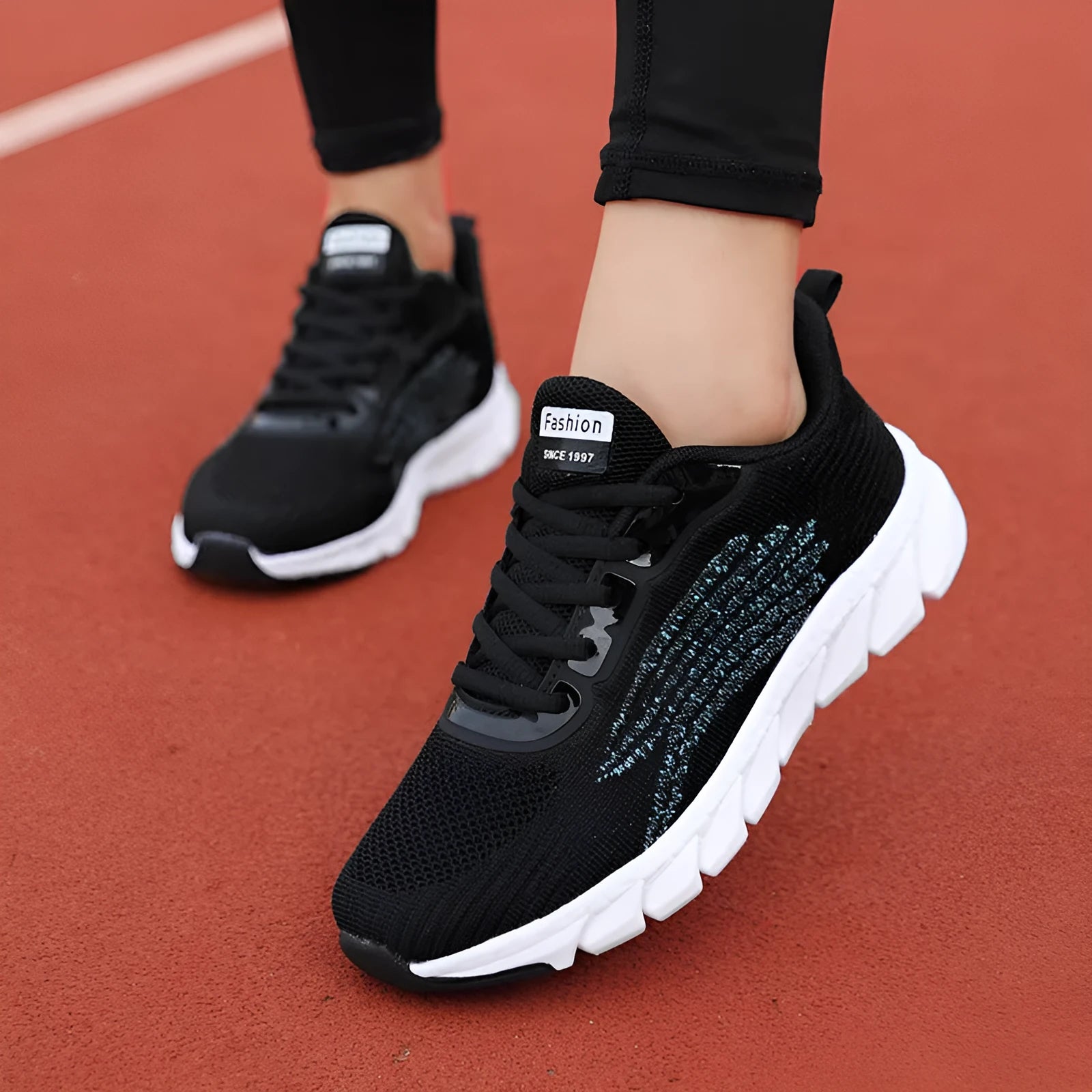 Black and white platform running sneakers with round toe and cross strap details