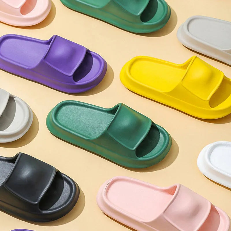 Soft EVA slippers with thick non-slip sole in various colours on a bathroom floor.